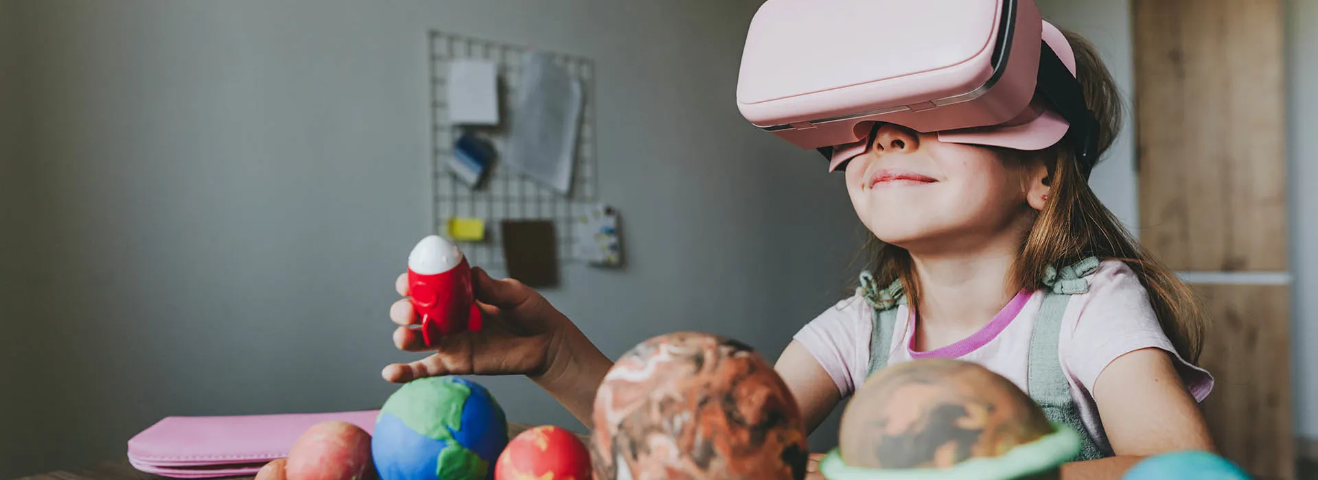girl with VR headset and spaceship toy 